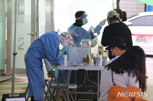 [서울=뉴시스]이윤청 기자 = 서울 강서구의 한 데이케어센터에서 20일 오전 8명이 추가 확진판정을 받아 서울에서 총 11명이 이날 추가 확진판정을 받았다. 20일 서울 강서구 보건소에 설치된 컨테이너형 워킹스루 선별진료소에서 시민들이 코로나19 검사를 받고 있다. 2020.07.20. radiohead@newsis.com