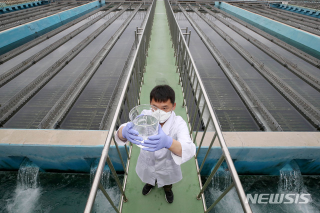 [서울=뉴시스]김병문 기자 = 서울시는 중구 소재 아파트 욕실에서 유충이 발견됐다는 신고와 관련해 "채수 시료에 대한 현미경 관찰 결과 수돗물에서 이물질 및 유충이 발견되지 않았다"고 20일 밝혔다. 사진은 이날 오후 서울 성동구 뚝도아리수정수센터 침전지에서 연구사가 체수한 뒤 육안으로 수질을 검사하고 있다. 2020.07.20.&nbsp; dadazon@newsis.com