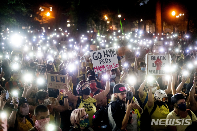 [포틀랜드=AP/뉴시스]미국 오리건주 포틀랜드에서 지난해 7월23일(현지시간) 인종 차별 반대 시위인 '흑인 생명도 소중하다'(BLM) 시위에 참여한 수백 명의 시위대가 휴대전화를 밝혀 들고 인종 정의를 외치고 있다. 2021.1.30.