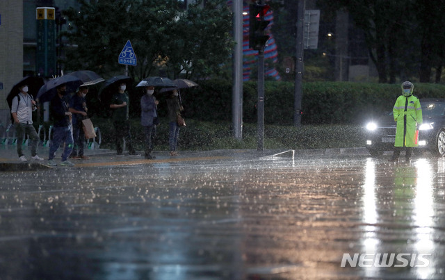[서울=뉴시스] 박미소 기자 = 서울에 호우주의보가 발효된 23일 오후 서울 종로구 광화문네거리에서 시민들이 우산을 쓰고 걸어가고 있다. 2020.07.23.&nbsp; misocamera@newsis.com