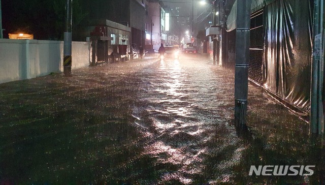 [부산=뉴시스] 하경민 기자 = 부산지역에 호우경보가 발효된 23일 오후 수영구의 한 주택가 이면도로가 침수돼 시민과 차량들이 힘겹게 이동하고 있다. 2020.07.23.  yulnetphoto@newsis.com