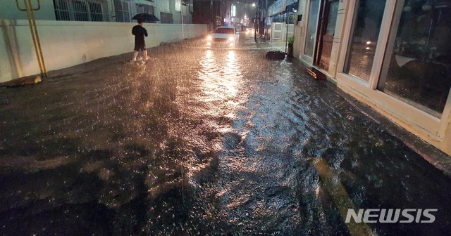 [부산=뉴시스] 하경민 기자 = 부산지역에 호우경보가 발효된 23일 오후 수영구의 한 주택가 이면도로가 침수돼 시민과 차량들이 힘겹게 이동하고 있다. 2020.07.23.  yulnetphoto@newsis.com