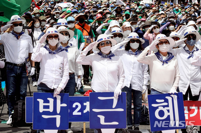 [서울=뉴시스]김병문 기자 = 박근혜 전 대통령의 석방을 촉구하는 시민들이 25일 오후 서울 중구 을지로입구역 인근에서 천만인무죄석방본부 주최, 우리공화당 주관으로 열린 제182차 태극기집회에 참석해 경례를 하고 있다. 2020.07.25. dadazon@newsis.com