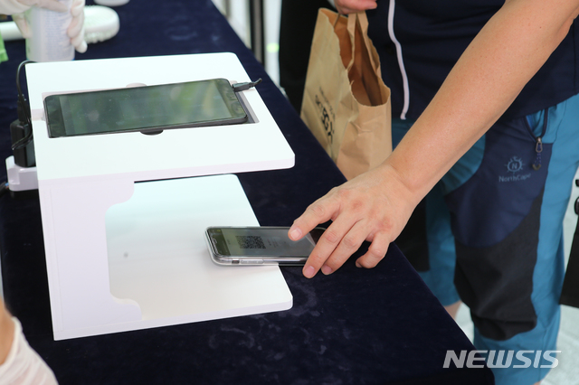 [서울=뉴시스] 고승민 기자 = 중앙재난안전대책본부의 프로스포츠 관중 입장 재개 발표에 따라 프로야구 경기부터 관중석의 10% 규모로 입장을 시작한 26일 서울 잠실야구장에서 열린 LG 트윈스 대 두산 베어스 경기를 찾은 시민들이 QR코드를 사용해 입장하고 있다. 2020.07.26. photo@newsis.com