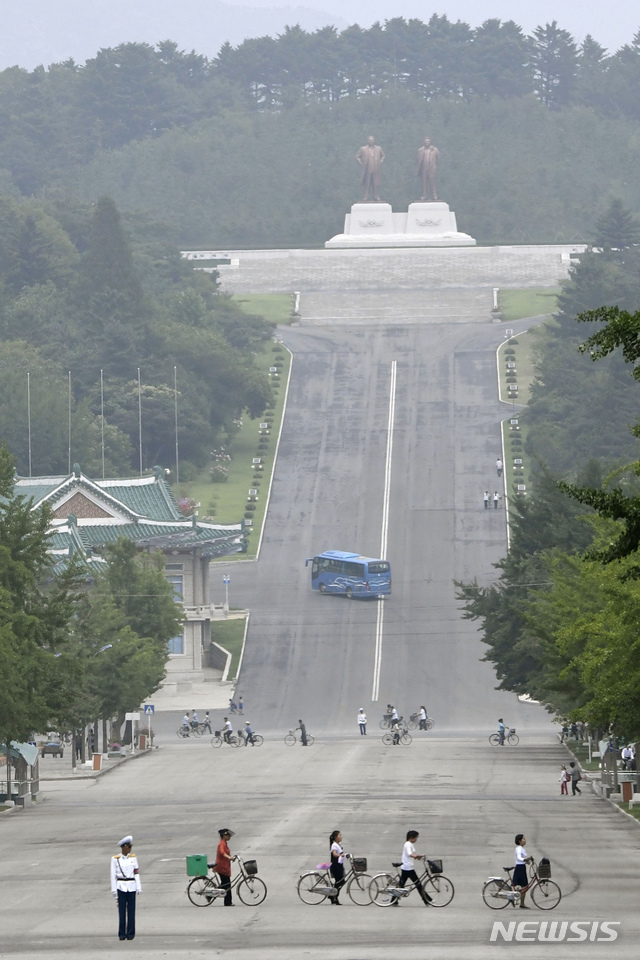 [개성=AP/뉴시스]김정은 북한 국무위원장이 개성에서 신종 코로나바이러스 감염증(코로나19)에 걸린 것으로 의심되는 탈북자가 월북하면서 개성시를 전면 봉쇄했다고 북한 관영매체가 26일 보도했다. 앞서 조선중앙통신은 "3년 전 탈북했던 한 주민이 코로나19에 걸린 채 지난 19일 북한으로 귀향하는 비상사건이 발생하였다"라고 전했다. 사진은 지난 23일 북한 개성에서 주민들이 길을 건너는 모습. 2020.07.26.