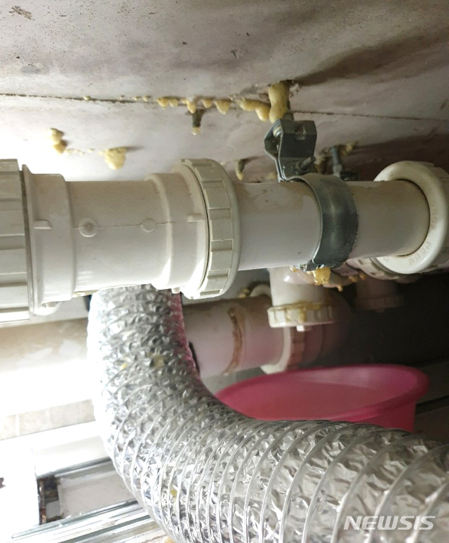 [나주=뉴시스] 이창우 기자 = 물이 새는 위층 배관 밑에 몰래 플라스틱 함지박을 받쳐 놓은 눈 속임 하자보수 행위가 들통이나 말썽이다. (사진= 독자 제공) 2020.07.27. photo@newsis.com