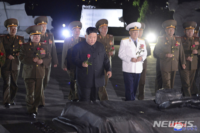 [평양=AP/뉴시스]북한이 27일 공개한 촬영 날짜 미상의 사진에 김정은(가운데) 북한 국무위원장이 정전협정 체결 67주년을 맞아 군 장교들과 함께 평양에 있는 조국해방전쟁 참전 열사 묘를 찾아 헌화 준비를 하고 있다. 2020.07.27