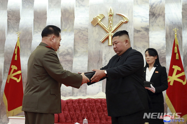 [평양=AP/뉴시스]북한이 26일 공개한 사진에 김정은(가운데) 북한 국무위원장이 평양의 당 중앙위원회 본부청사에서 열린 한국전쟁 정전협정 체결 67주년 기념행사를 주관하며 군 고위 간부에게 '백두산' 기념 권총을 수여 하고 있다. 오른쪽에 김 위원장의 동생이 김여정 당 중앙위원회 제1부부장이 그를 보좌하고 있다. 2020.07.27.