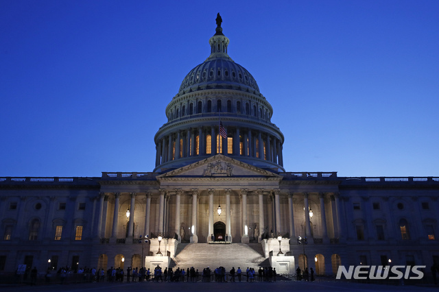 [워싱턴=AP/뉴시스]27일 미 워싱턴 DC의 국회의사당에 안치된 존 루이스 하원의원에 조의를 표하기 위해 모인 미 국민들이 성조기가 덮힌 루이스 의원의 관을 지켜보고 있다. 이날 낸시 펠로시 하원 의장과 미치 매코널 상원 공화당 원내대표, 마이크 펜스 부통령, 조 바이든 전 부통령 등 많은 사람들이 루이스 의원에 조의를 표하기 위해 의사당을 찾았지만 도널드 트럼프 미 대통령은 루이스 의원에게 조의를 표하기 위해 의사당에 가지 않겠다고 말했다. 2020.7,28 