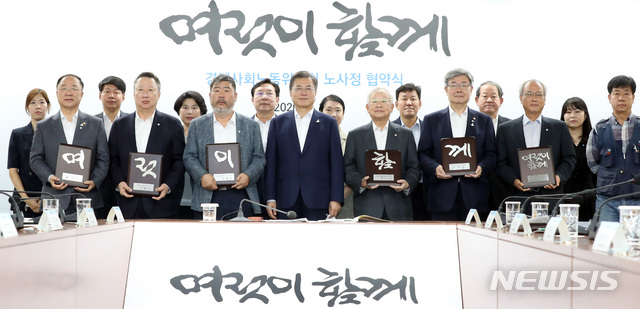 [서울=뉴시스]박영태 기자 = 문재인 대통령이 28일 서울 종로구 경제사회노동위원회 대회의실에서 열린 경제사회노동위원회의 ‘코로나19 위기 극복을 위한 노사정 협약식’에서 협약서에 서명 후 '여럿이 함께'라는 글이 써진 기념패를 든 노사정위원회 위원들과 기념촬영을 하고 있다. 2020.07.28. since1999@newsis.com