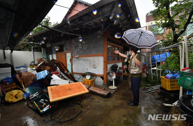 [광주=뉴시스] 신대희 기자 = 29일 집중 호우로 침수 피해를 입은 광주 북구 중흥3동 한 주택에서 주민이 젖은 가재도구를 마당에 쌓아둔 뒤 침수 당시 상황을 설명하고 있다. 2020.07.29.&nbsp; sdhdream@newsis.com