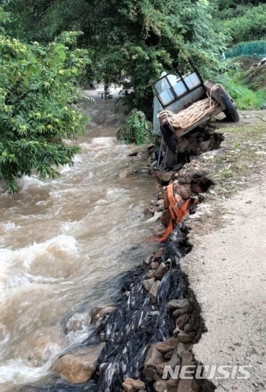 [충주=뉴시스]이병찬 기자 = 30일 천둥과 번개를 동반한 많은 비가 내린 충북 충주시 앙성면의 한 농로에 경운기가 위태롭게 걸려 있다.(사진=충주시 제공).2020.07.30. bclee@newsis.com