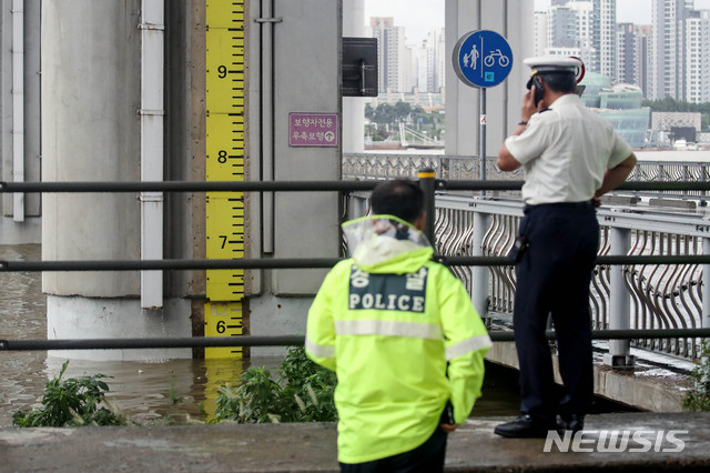 [서울=뉴시스]김병문 기자 = 잠수교 수위가 5.5m에 이르러 보행자와 자전거가 통제된 2일 오후 서울 용산구 잠수교에서 교통경찰들이 수위를 확인하고 있다. 2020.08.02. dadazon@newsis.com
