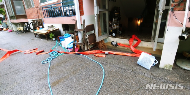 [연천=뉴시스] 이호진 기자 = 3일 경기 연천군 연천읍의 한 연립주택 입구에 전날부터 이어진 집중호우로 침수됐던 지하 창고에서 물을 빼낸 뒤 치우지 못한 호스가 남아있다. 2020.08.03. asake@newsis.com 