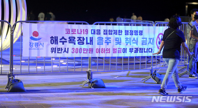 [강릉=뉴시스] 김경목 기자 = 4일 오후 강원 강릉시청 공무원들이 강릉시 경포해수욕장 중앙통로에서 신종 코로나바이러스 감염증 예방을 위한 해수욕장 야간 음주·취식금지 집합제한 행정명령을 피서객들에게 알리고 있다. 2020.08.04.&nbsp;&nbsp; photo31＠newsis.com