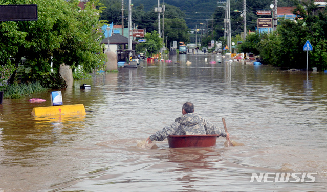 [서울=뉴시스]강원도 철원지역에 폭우가 쏟아져 침수된 5일 철원군 김화읍 생창리 일대 주택이 침수돼 한 노인이 고무대야를 타고 대피하고 있다. (사진=강원도민일보 제공) 2020.08.05.&nbsp; photo@newsis.com