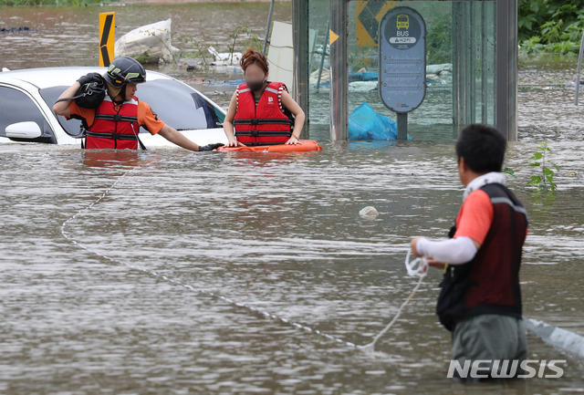 [파주=뉴시스] 이윤청 기자 = 6일 경기 파주시 파평면 율곡리 일대 도로가 폭우로 인한 임진강 수위 상승으로 물에 잠긴 가운데 주행 중이던 차량이 침수되어 119 구조대원이 운전자를 구조하고 있다. 2020.08.06.&nbsp; radiohead@newsis.com