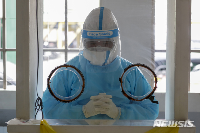 [마닐라=AP/뉴시스]6일(현지시간) 필리핀 마닐라 내 병원의 신종 코로나바이러스 감염증(코로나19) 검사 시설에서 의료진이 기도하고 있다. 2020.8.6.