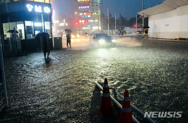 [부산=뉴시스] 부산지역에 호우경보가 발효된 지난 7일 오후 부산 해운대구의 한 도로가 침수돼 차량과 시민들이 힘겹게 이동하고 있다. (사진=부산경찰청 제공). 2020.08.07. photo@newsis.com