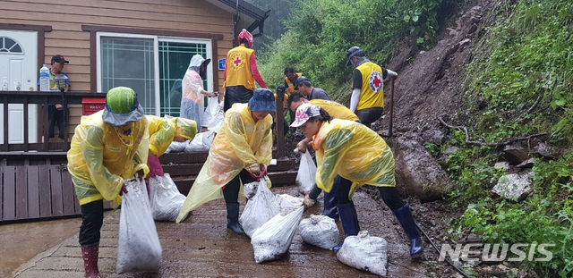[서울=뉴시스] 6일 충북 제천 창선리 침수피해 가구에서 적십자 봉사원들이 수해폐기물을 봉투에 담고 있다. (사진=대한적십자사 제공) 2020.08.07. photo@newsis.com