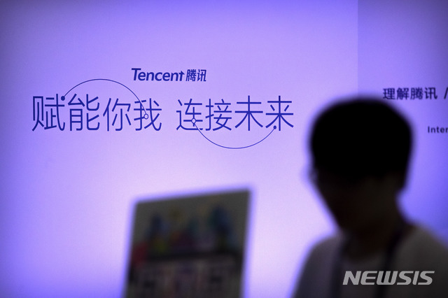 [베이징=AP/뉴시스] 2017년 4월27일(현지시간) 중국 베이징에서 열린 글로벌모바일인터넷회의(GMIC)에서 한 참가자가 중국 기술 기업 텐센트 부스 앞을 지나가고 있다. 텐센트는 중국판 카카오톡인 위챗의 모기업이다. 2020.08.07. 