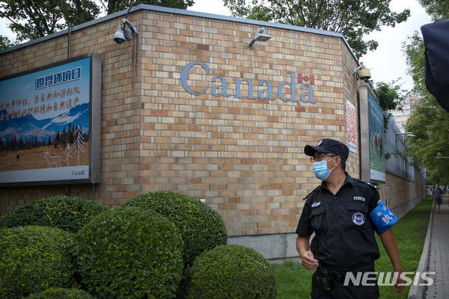[베이징=AP/뉴시스]중국 베이징 주재 캐나다대사관 밖에 6일 신종 코로나바이러스 감염증(코로나19)으로부터 보호를 위해 마스크를 쓴 보안요원이 서 있다. 중국은 6일 캐나다인 쉬웨이훙에게 마약 혐의로 사형을 선고한데 이어 7일에도 예젠후이에게 사형을 선고, 이틀 새 2명의 캐나다인에게 사형을 선고했다. 이는 멍완저우(孟晩舟) 화웨이 최고 재무책임자(CFO)가 캐나다에 체포된 후 2년도 못돼 벌써 4번째 캐나다인에 대한 사형선고이다. 2020.8.7
