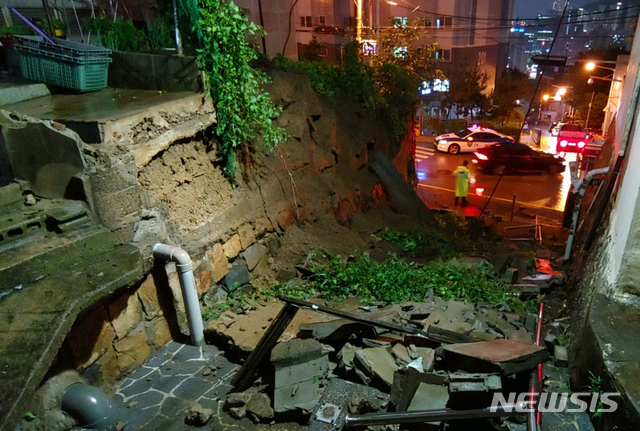 [부산=뉴시스] 부산지역에 호우경보가 발효된 7일 밤 연제구 만수사 계단 옆 옹벽(길이 15m)이 무너졌다. (사진=부산경찰청 제공). 2020.08.08.&nbsp;&nbsp;&nbsp;&nbsp; photo@newsis.com