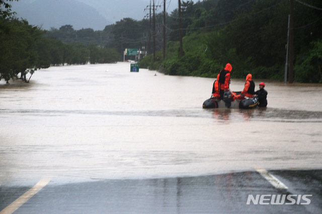 [하동=뉴시스]차용현 기자 = 8일 오후 이틀째 퍼부은 집중 호우로 섬진강이 범람하자 119 구조대가 경남 하동군 신지마을 인근에서 고립된 주민을 구조하기 위해 물에 잠겨버린 국도 19호선 위를 고무보트로 이동하고 있다. 2020.08.08.&nbsp; con@newsis.com