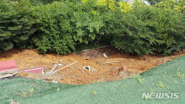 [부산=뉴시스] 9일 오전 11시 30분께 부산 남구 대한상공회의소 부산인력개발원 운동장 가장자리에서 높이 10m, 폭 40m 크기로 붕괴됐다. (사진=부산경찰청 제공)