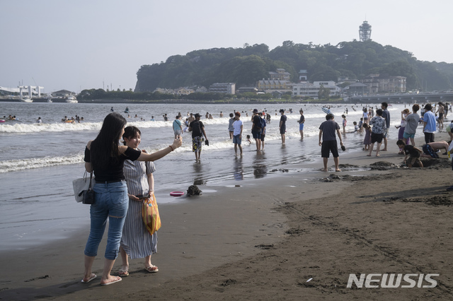 [도쿄=AP/뉴시스] 일본에서 신종 코로나바이러스 감염증(코로나19)가 좀처럼 진정되지 않는 가운데 최대명절 오봉 연휴를 맞아 9일 인파가 도쿄 서쪽 후지사와 에노시마섬 해변에 몰려와 해수욕을 하거나 기념촬영을 하면서 하루를 보내고 있다. 2020.08.09