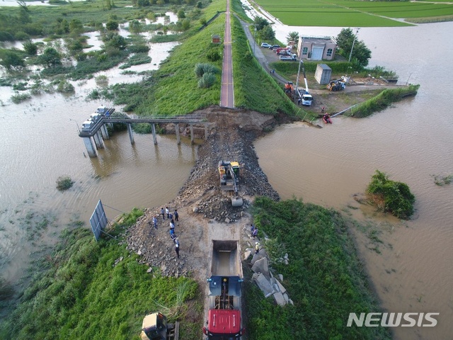 [창녕=뉴시스] 홍정명 기자=지난 9일 새벽 무너진 경남 창녕군 이방면 장천배수장 인근 낙동강 제방이 수자원공사의 긴급 복구 적업으로 9일 밤 8시께 유실 제방 성토이음 작업이 완료됐다. 수자원공사는 10일 밤 8시까지 완전복구 후 방수포 작업까지 마무리한다는 계획이다.(사진=창녕군 제공) 2020.08.10.&nbsp; photo@newsis.com 
