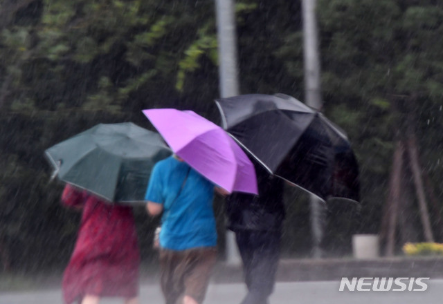 [부산=뉴시스] 하경민 기자 = 제5호 태풍 '장미'가 북상함에 따라 부산지역에 태풍주의보가 발효된 10일 오후 해운대해수욕장을 찾은 시민들이 비바람에 맞서 힙겹게 걸어가고 있다. 2020.08.10.&nbsp; yulnetphoto@newsis.com