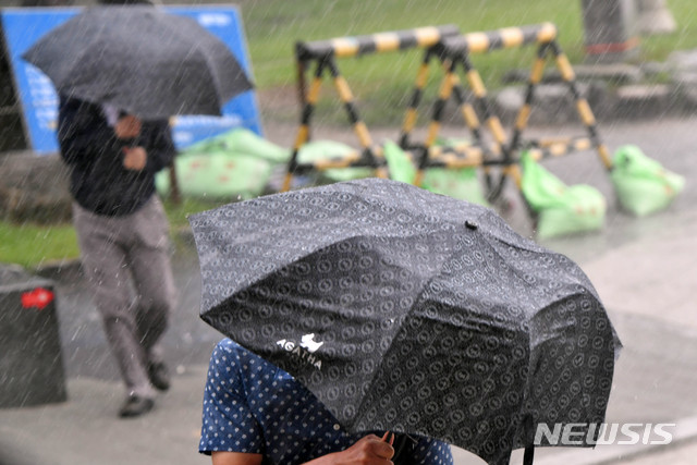 [부산=뉴시스] 하경민 기자 = 지난 10일 오후 해운대해수욕장을 찾은 시민들이 비바람에 맞서 힙겹게 걸어가고 있다. 2020.08.10.&nbsp; yulnetphoto@newsis.com
