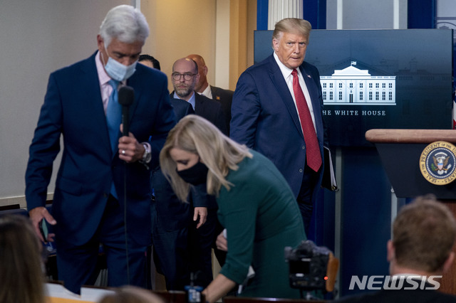 [워싱턴=AP/뉴시스]도널드 트럼프 미국 대통령(정면)이 10일(현지시간) 백악관 외부 총격으로 중단됐던 신종 코로나바이러스 감염증(코로나19) 브리핑 재개를 위해 브리핑룸으로 들어서고 있다. 2020.08.11.