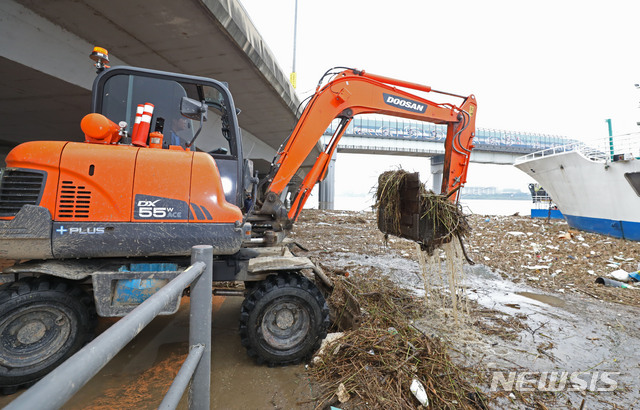 [서울=뉴시스] 박미소 기자 = 비가 소강상태를 보인 12일 오전 서울 마포구 망원한강공원에 강물에 떠내려온 부유물들을 관계자들이 치우고 있다. 2020.08.12.&nbsp; misocamera@newsis.com