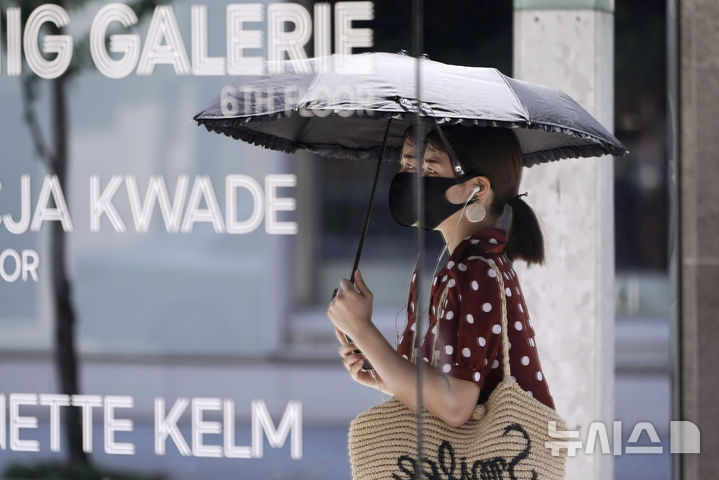 [도쿄=AP/뉴시스]일본 도쿄의 한 상점 거울에 여성이 비쳐진 모습.2024.12.10