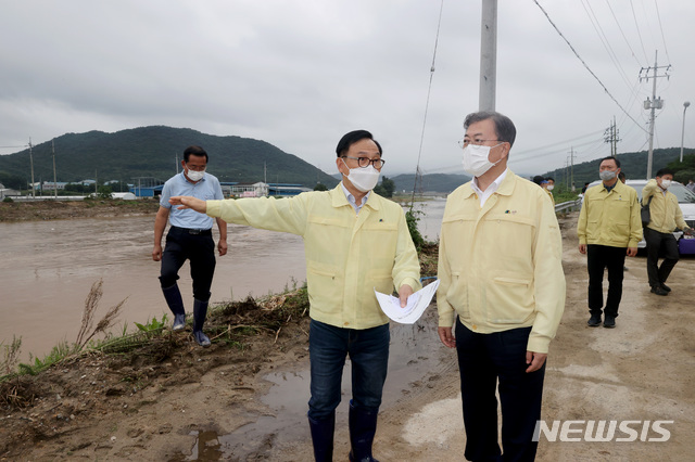 [천안=뉴시스]배훈식 기자 = 집중호우 피해현장 방문에 나선 문재인 대통령이 12일 폭우로 무너진 충남 천안시 병천천 제방을 찾아 복구계획 등을 보고 받고 있다. 2020.08.12. dahora83@newsis.com