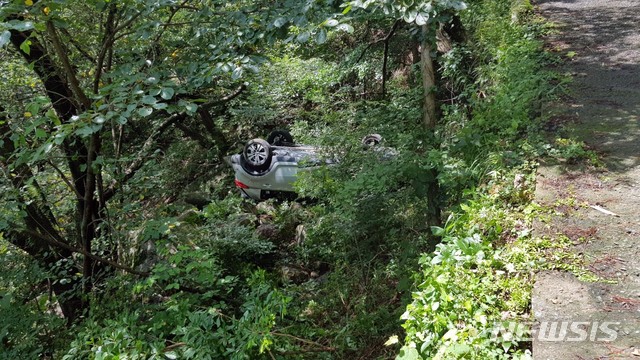 [부산=뉴시스] 13일 오전 11시 30분께 부산 북구의 한 산길을 달리던 스포티지 차량이 도로 아래로 추락했다. (부산경찰청 제공)