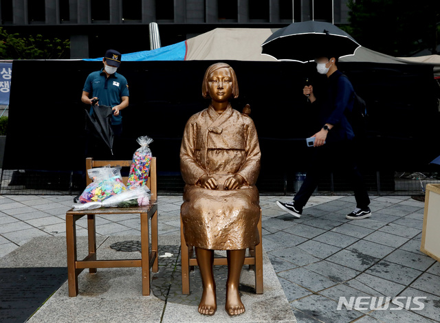 [서울=뉴시스]김병문 기자 = 일본군'위안부' 피해자 기림의 날인 지난해 8월14일 오전 서울 종로구 옛 일본대사관 앞 평화의 소녀상 뒤로 시민들이 이동하고 있다. 2020.08.14. dadazon@newsis.com