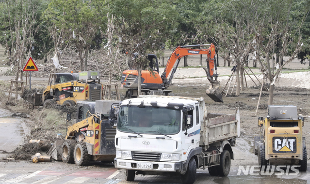 [서울=뉴시스] 한강공원 관계자들이 14일 서울 서초구 반포 한강공원에서 떠밀려온 쓰레기와 나뭇가지 등을 치우고 있다. 사진은 기사와 무관. (사진=뉴시스DB) photo@newsis.com