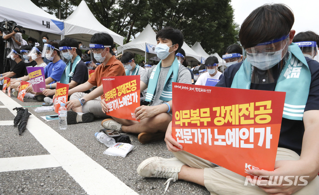 [서울=뉴시스] 최진석 기자 = 의사들이 14일 서울 영등포구 여의대로에서 대한의사협회 주최로 열린 의료 4대악 정책추진 반대 전국 의사 총파업 궐기대회에 참석해 피켓을 들고 묵념하고 있다. 2020.08.14. myjs@newsis.com