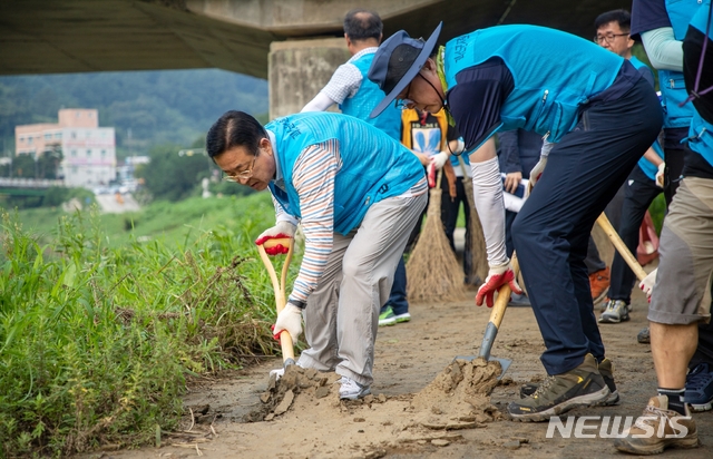 [괴산=뉴시스]강신욱 기자 = 이차영 괴산군수가 15일 간부공무원들과 함께 괴산읍 남산교 등의 산책로에서 집중호우로 쌓인 토사를 제거하고 있다. (사진=괴산군 제공) 2020.08.15. photo@newsis.com 