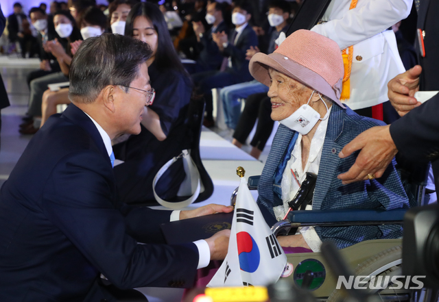 [서울=뉴시스]배훈식 기자 = 문재인 대통령이 15일 오전 서울 동대문디자인플라자에서 열린 제75주년 광복절 경축식에 참석하여 독립유공자 고 최사진 씨의 부인 박명순 씨에게 대통령 표창을 수여한 후 인사하고 있다. 2020.08.15. dahora83@newsis.com