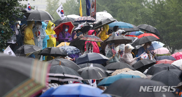 [서울=뉴시스]추상철 기자 =보수단체 집회 참가자들이 15일 오전 서울 종로구 광화문광장에서 우산을 쓰고 집회에 참가하고 있다. 2020.08.15.&nbsp; scchoo@newsis.com