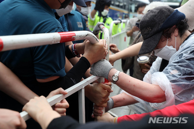 [서울=뉴시스]추상철 기자 =보수단체 집회 참가자가 전날 오전 서울 종로구 광화문광장에서 8·15 국민대회 집회중 경찰이 세워놓은 바리게이트를 넘으려고 시도하고 있다. 2020.08.15.  scchoo@newsis.com