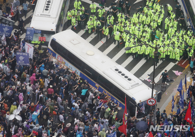 [서울=뉴시스]김명원 기자 = 지난 15일 서울 종로구 광화문 광장 열린 보수단체 8·15 대규모 집회 참가자들이 경찰 저지선을 뚫고 사직로에서 청와대로 가는길로 몰려와 경찰들과 대치하고 있는 가운데 일부 집회 참가자들이 경찰 버스를 넘어트리려는 듯 밀고 있다. 2020.08.15. kmx1105@newsis.com