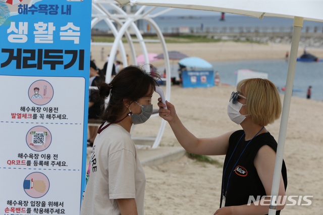 [강릉=뉴시스] 김경목 기자 = 16일 오전 강릉시 방역요원이 강원 강릉시 강문해수욕장 출입구에서 신종 코로나바이러스 감염증(코로나19) 확산 예방을 위해 피서객의 몸 온도를 재고 있다. 2020.08.16.&nbsp;&nbsp; photo31＠newsis.com