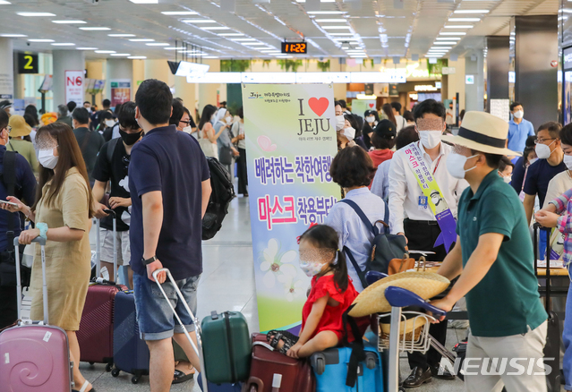 [제주=뉴시스]우장호 기자 = 광복절 황금연휴 마지막 날인 17일 제주국제공항 1층 도착장에서 신종 코로나바이러스 감염증(코로나19) 예방을 위한 '마스크 착용' 캠페인이 진행되고 있다. 2020.08.17.   woo1223@newsis.com