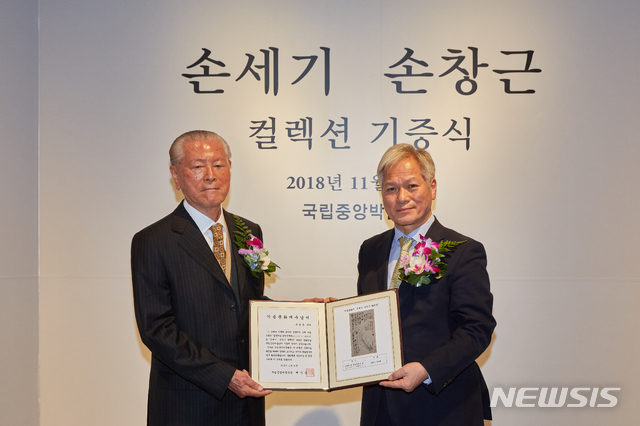 [서울=뉴시스] 2018년 11월 '손세기·손창근 컬렉션' 기증 당시 손창근씨와 배기동 국립중앙박물관장.(사진=국립중앙박물관 제공) 2020.8.20 photo@newsis.com