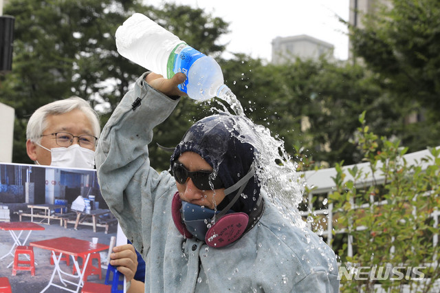 [서울=뉴시스] 박민석 기자 = 건설현장 폭염 실태 폭로 및 대책 촉구 기자회견이 열린 지난 20일 서울 종로구 정부서울청사 앞에서 플랜트건설노조 경인지부 용접공 서재훈씨가 머리에 생수를 붓고 있다. 2020.08.20. mspark@newsis.com